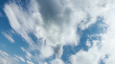 Yumuşak beyaz bulutlar uçsuz bucaksız mavi gökyüzünde yavaşça sürüklenerek sakin ve rüya gibi bir atmosfer yaratır..