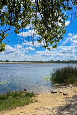 Ukrayna 'nın Kiev kentindeki Dinyeper Nehri' nin sakin manzarası sakin suları gün ışığı altında ve berrak bir gökyüzü altında şehre akıyor..