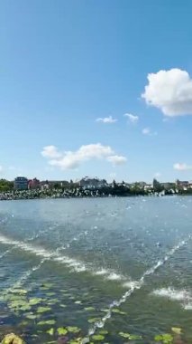 Ternopil, Ukrayna 'daki Ternopil göleti boyunca sakin suların ve bereketli çevrenin sakin bir kent inzivası yarattığı huzurlu bir yürüyüş gerçekleşir..