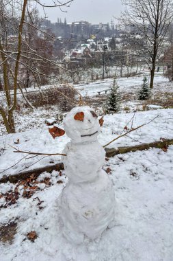 İlk kar yağışından doğan neşeli bir kardan adam bir parkta duruyor, Ukrayna, Kyiv 'de kışın neşeli başlangıcını yakalıyor..