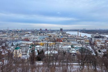 KYIV, UKRAINE - 4 Ocak 2026: Karlı Podil 'in panoramik bir görüntüsü Volodymyrska Tepesi' nden yayılıyor, Ukrayna 'nın başkenti Kyiv' de sakin bir kış şehri ortaya çıkarıyor.