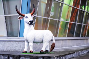 Kardan yapılmış boğa figürü, kış şehri manzarası. Kış tatili geçmişi. Tebrik kartı tasarımı. Arkaplan duvarı