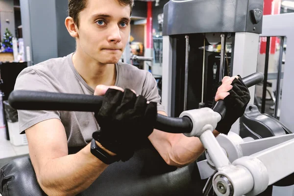 Młody Mężczyzna Ćwiczy Symulatorze Siłowni Trenuje Siłę Mięśni Koncepcja Zdrowego — Zdjęcie stockowe