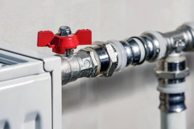 Kırmızı termostat aksesuarı. Tesisat servisi. Krom kaplamalı ısıtma sistemi boru bağlantıları.