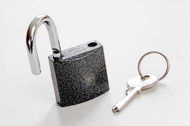 Anahtarla asma kilidi aç. Beyaz arka planda yakın plan. Güvenlik kavramı.