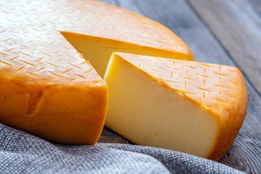 Kavramsal tasarım için kesilmiş bir parçayla olgunlaşmış bir Gürcistan suluguni peyniri. Beslenme kavramı.