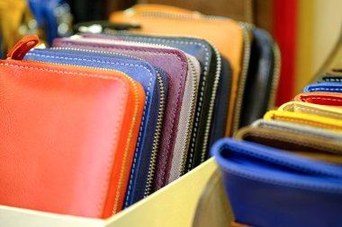 Gerçek deriden yapılmış çok renkli çantalar, pencereye istiflenmiş.