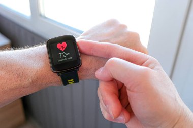 Akıllı teknolojiler. Bir kişi spor saatinin ayarlarını açık hava eğitimi için ayarlar.