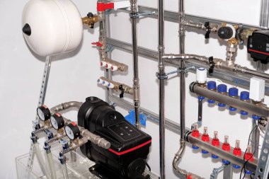 Tesisat servisi. Kazan dairesindeki ısıtma sisteminin paslanmaz çelik boruları. Isıtma ısı düzenleme sistemi. Pompa ve sensörler. Beyaz arka planda yakın plan. İş konsepti. Modern tasarım.