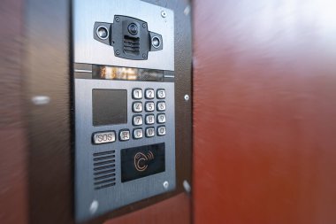 Eve gelen aramaları kaydetme yeteneğine sahip dijital dahili telefon. Kodu girmek için düğmeler ve manyetik okuyucu. Evin önünde dahili telefon var.