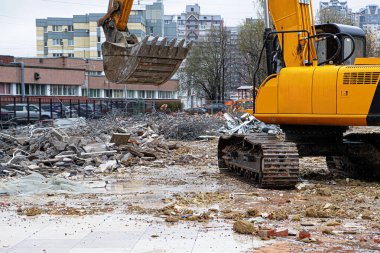 Yasadışı olarak inşa edilmiş bir binayı söktükten sonra bir çöp yığını arasında kazıcı