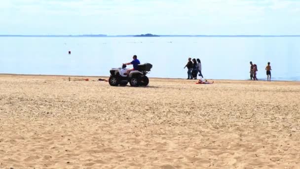 Przejażdżka quadem wzdłuż wału. Koncepcja szczęśliwej rodziny. Koncepcja letniego wypoczynku na plaży. Piękna plaża. Sankt-Petersburg. Rosja. 6 czerwca 2021 r. — Wideo stockowe