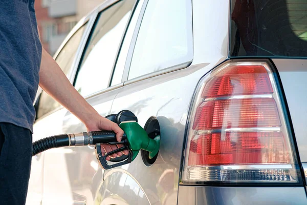 Tankstellenkolonne. Der Fahrer steckte eine Tankpistole in den Tank, während er das Auto an der Tankstelle mit Benzin befüllte. — Stockfoto