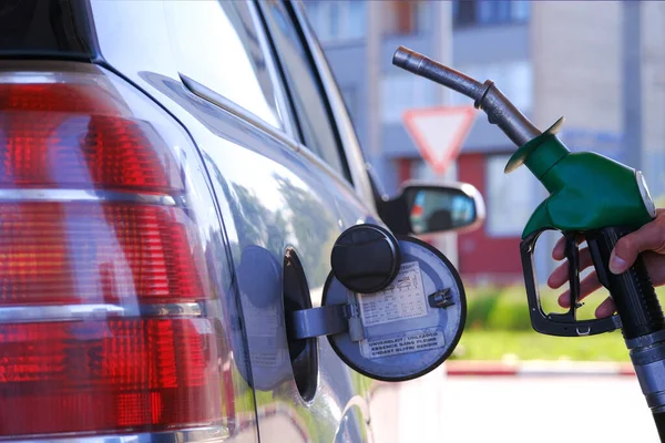 Tankstellenpistole in der Hand des Fahrers. Moderne Tankstellenpumpe, ausgezeichnetes Design für jeden Zweck. Der Fahrer des Autos. — Stockfoto