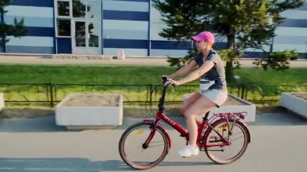 Chica joven con estilo en un paseo en bicicleta en un carril bici. San Petersburgo. Rusia. 21 de junio de 2021 — Vídeos de Stock