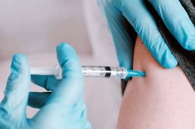 Hastaya aşı yapan doktor. Koronavirüs enfeksiyonuna karşı aşı. Deri altı enjeksiyonunun tıbbi konsepti.