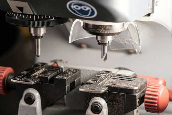 A copy machine for making keys. A milling cutter for cutting a duplicate. The locksmiths theme. Key blanks for cutting.