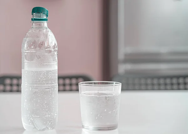Μπουκάλι φρέσκο νερό backlighting στο παρασκήνιο με σταγονίδια νερού — Φωτογραφία Αρχείου