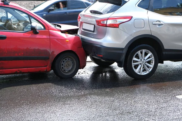 En bilolycka på gatan med skadade bilar efter en kollision. Stötfångaren, strålkastarna och huven är trasiga. — Stockfoto