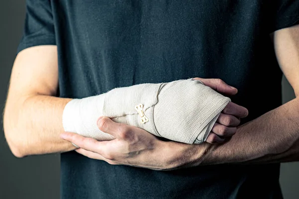 Sports injury of the hand. Primary care, the hand is tightly fixed with an elastic bandage. — Stock Photo, Image