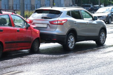 Tampon, farlar ve kaput kırılmış. Çarpışmadan sonra hasarlı arabalarla sokakta bir araba kazası..