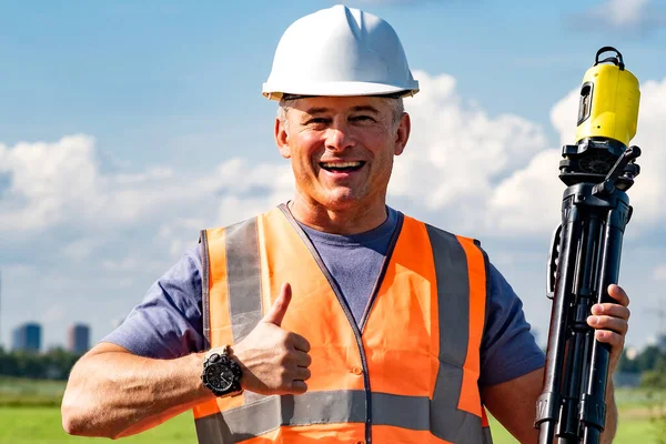 A construction worker in a white helmet, at arms length, gives a thumbs up that everything is very good. — Stock Photo, Image