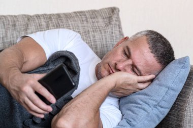 SMS mesajlarını okuyor. Depresyon, kötü sağlık. Duygusuz bir durum. Uzaktan bakan bir adam. Zihinsel bozukluk kavramı