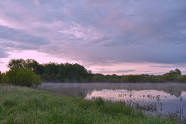 Renkli ve sisli bir şafak küçük bir nehrin üzerinde