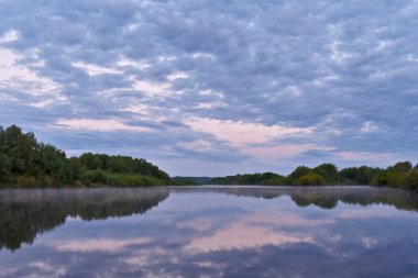 Renkli ve sisli bir şafak küçük bir nehrin üzerinde
