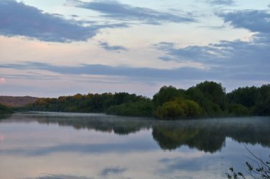 Renkli ve sisli bir şafak küçük bir nehrin üzerinde