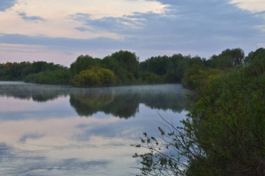 Renkli ve sisli bir şafak küçük bir nehrin üzerinde