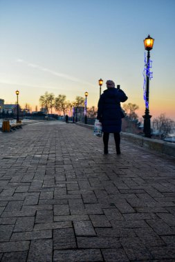 Turistler gün batımının fotoğraflarını çeker.
