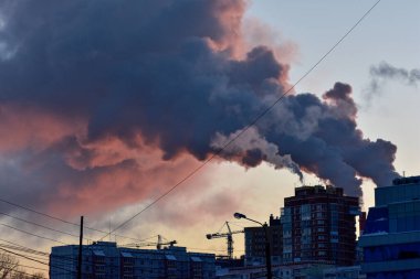 Gün batımında endüstriyel borulardan duman çıkıyor