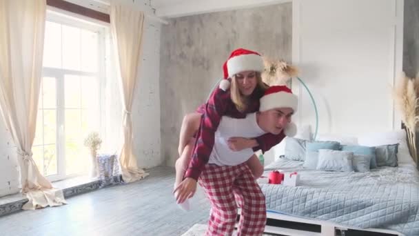 Christmas Mood Woman Santa Hat Pajamas Climbed Back Man Dabbing — Stock Video