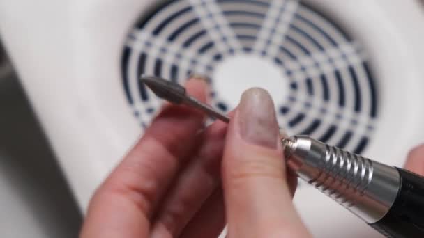 4k. Hardware manicure. Schoonheid en gezondheidszorg concept. Close-up van vrouwen handen veranderen manicure mondstukken tegen de achtergrond van een ventilator zuigen stof van nagels — Stockvideo