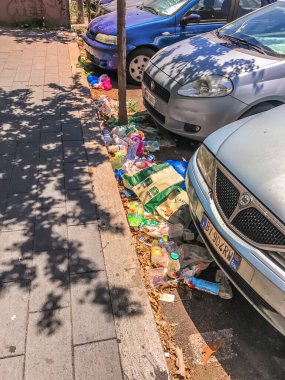 Çöp, çevre kirliliği. Paketler ve plastik şişeler caddenin ortasında, arabaların yanında duruyordu. Roma, İtalya, 18 Haziran 2017