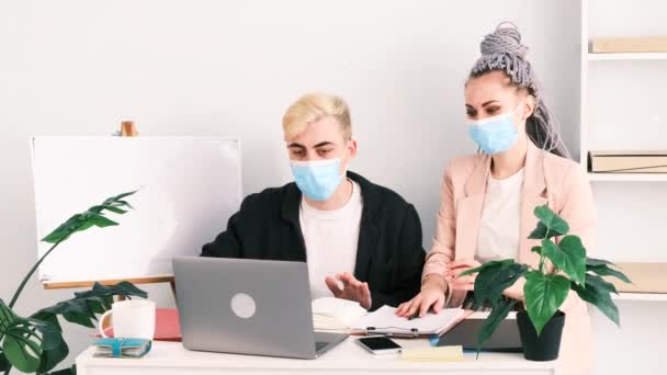 기업 비즈니스, 온라인 콘퍼런스. 정식 자켓을 입고 의료용 마스크를 쓴 사람들은 사무실에 있는 랩탑을 사용하여 의사 소통을 한다. 동료들은 성공적 인 컨퍼런스를 마치고 서로에게 5 년을 줍니다.. — 비디오