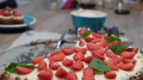 Délicieux gâteau au fromage maison à la fraise avec menthe sur fond de tasse de cappuccino, mise au point sélective, 4k — Video