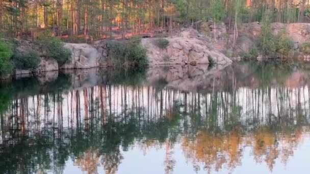 Widok na piękny zalany kamieniołom granitowy z błękitną wodą wśród sosnowego lasu w słoneczny letni dzień, 4k — Wideo stockowe