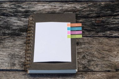 Eski ahşap masanın üzerine renkli nota sekmesi, klasik resim tonuyla yakın plan defter görüntüsü. Amaca ulaşmak için kaydedilen çalışma fikri. Boşluğu kopyala.