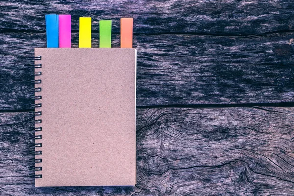 Renkli defter, eski ahşap masaya sekme. Mesaj ya da tebrik kartı arkaplanı için günlük ekle, kopyalama alanı ile kavram oluştur. Klasik resim tonu, Üst görünüm, düz yatış,