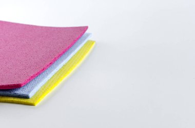 Renkli sünger temizleme bezleri kopi alanının beyaz arkaplanını kapatır