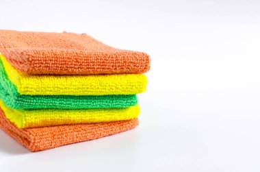 Renkli bez temizleme havluları beyaz arka plandaki havlu yığınına kapanıyor.