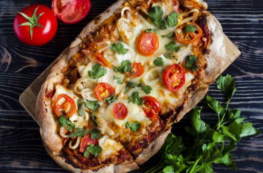 Koyu ahşap arka plan manzaralı domatesli taze pinsa. Pinsa ev yemeği. Pizza hamur işleri.