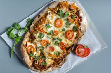 Domates ve yeşillik şeklinde bir dekoru olan pinsa beyaz kağıt üzerinde maden alanının üst görüntüsü. Pinsa ev yemeği. Pizza hamur işleri.