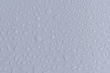 Maden sahasının mavi zemininde büyük ve küçük su damlaları. Suyun dokusu üst görünümü düşürür.