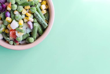 Renkli arka plan manzaralı donmuş sebzeler. Salgında yiyecek kavramı hafif tabaklarda donmuş sebzeler kopi uzayında