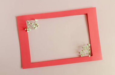 Madenin arka planında beyaz çiçeklerle süslenmiş renkli bir çerçeve. Düz kırmızı çerçeve ve çiçek dekoru