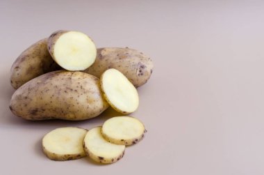 Renkli bir arka planda patates ve yarım patates. Kopi uzayının renkli arka planında patatesler