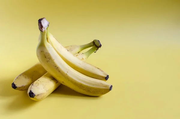 Ripe bananas on a yellow background of kopi space. Bananas for sale